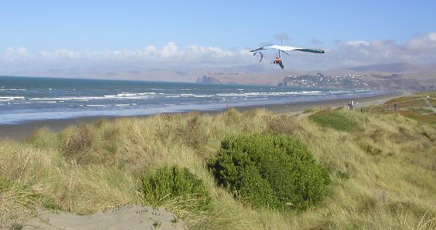 Kiter und Drachenflieger am Strand